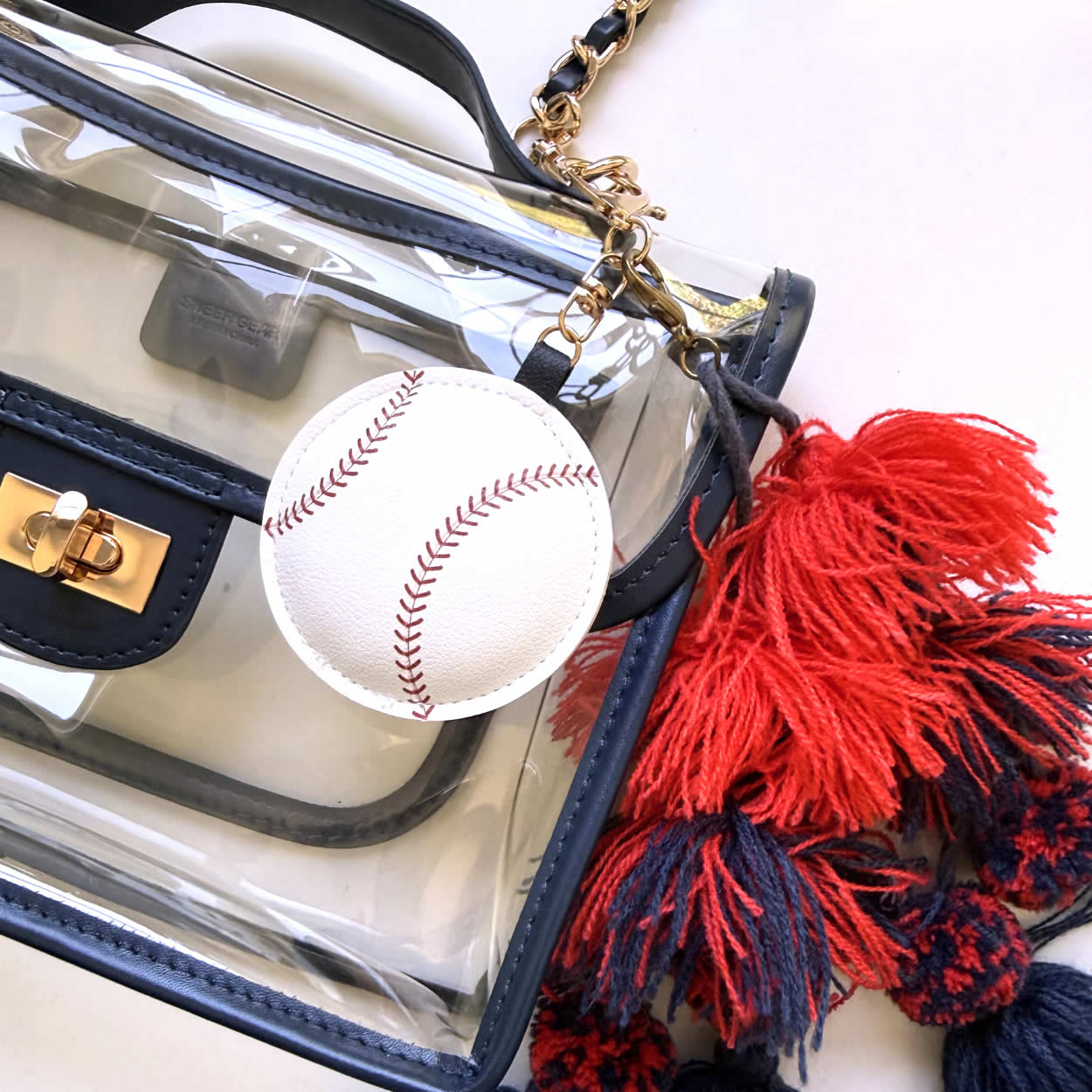 Faux-leather baseball charm clipped to a clear, stadium-approved purse