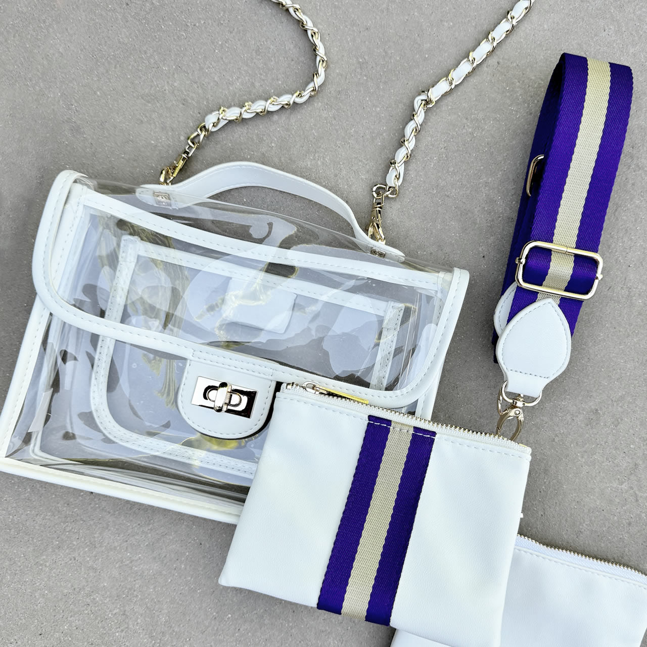 Clear, stadium approved purse with white trim and striped purple and gold strap