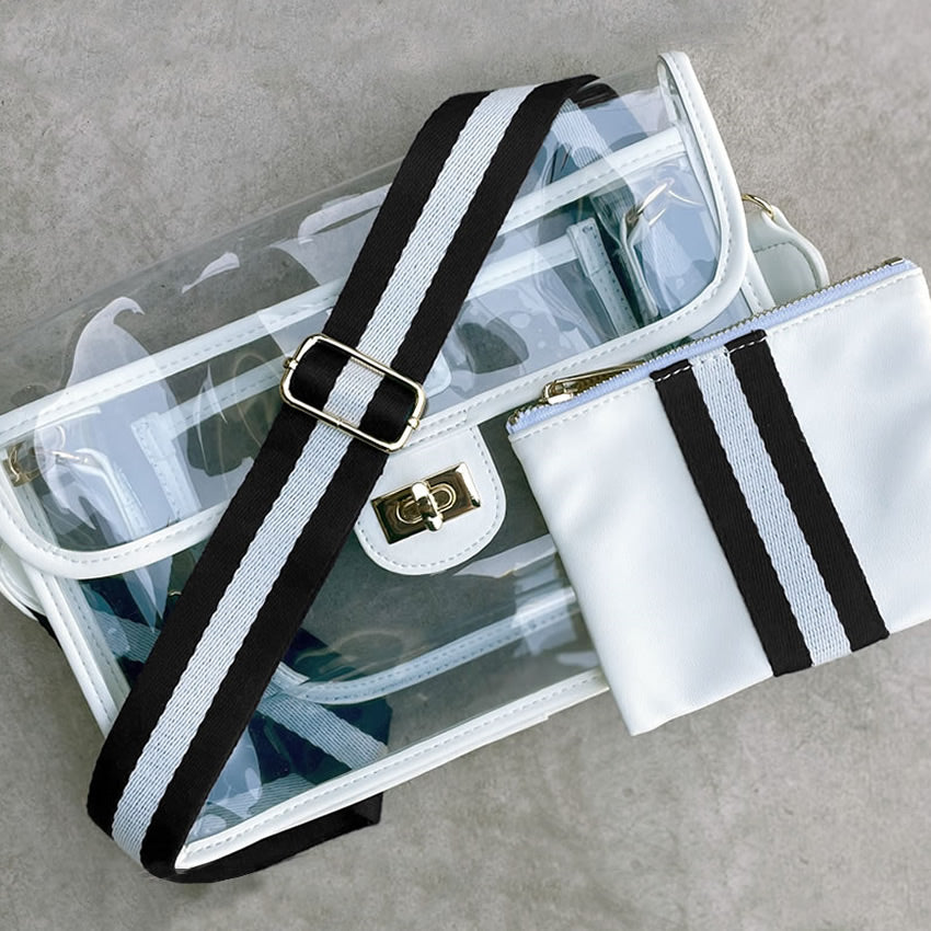 Clear stadium purse with black strap and white pouch on a gray surface