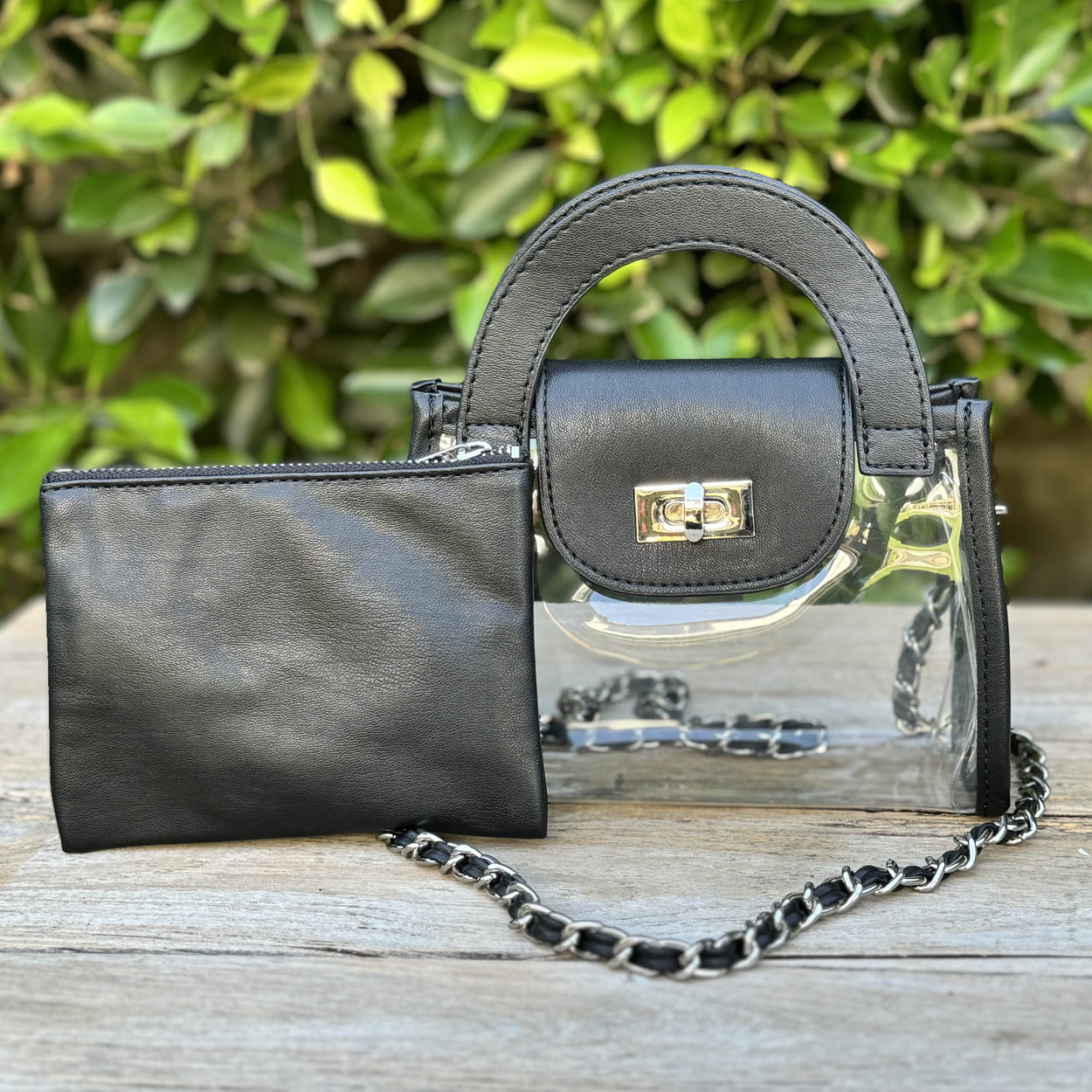 Clear, stadium-approved fashion purse with black faux-leather trim and a silver chain