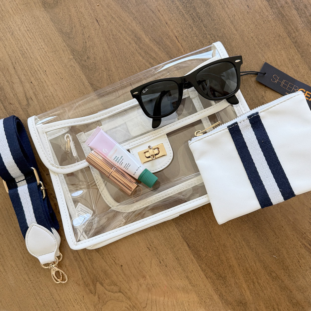Clear stadium approved purse with sunglasses and toiletries on matching accessory pouch