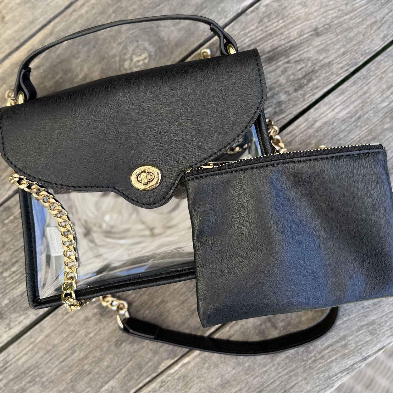 Black handbag with clear front panel and gold chain for stadium approved entry