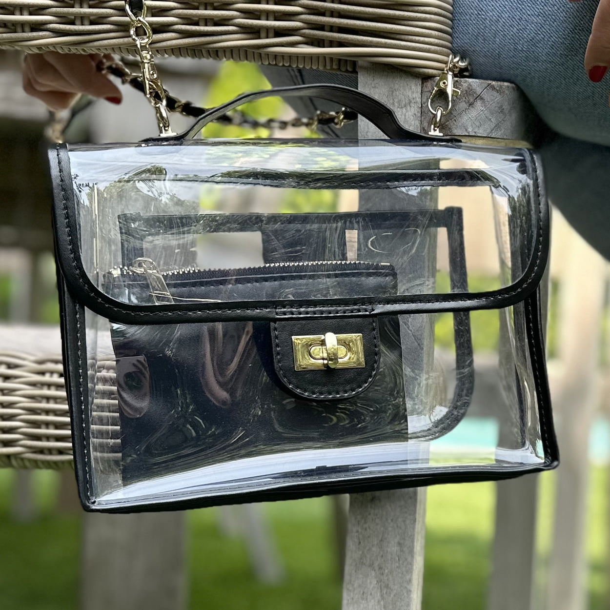 Clear, stadium-approved purse with black trim and gold chain