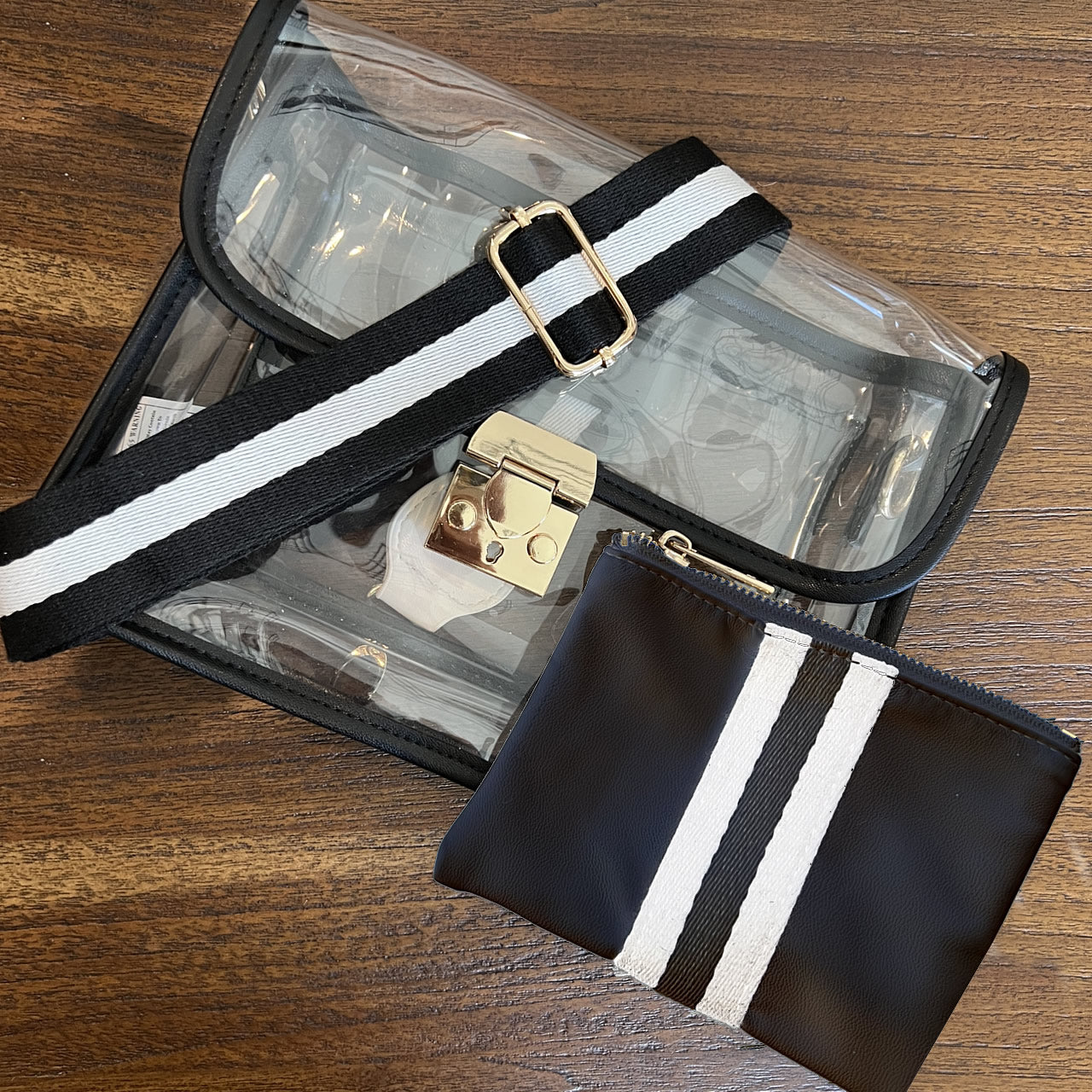 Stadium approved handbag with black and white striped strap and accessory pouch.