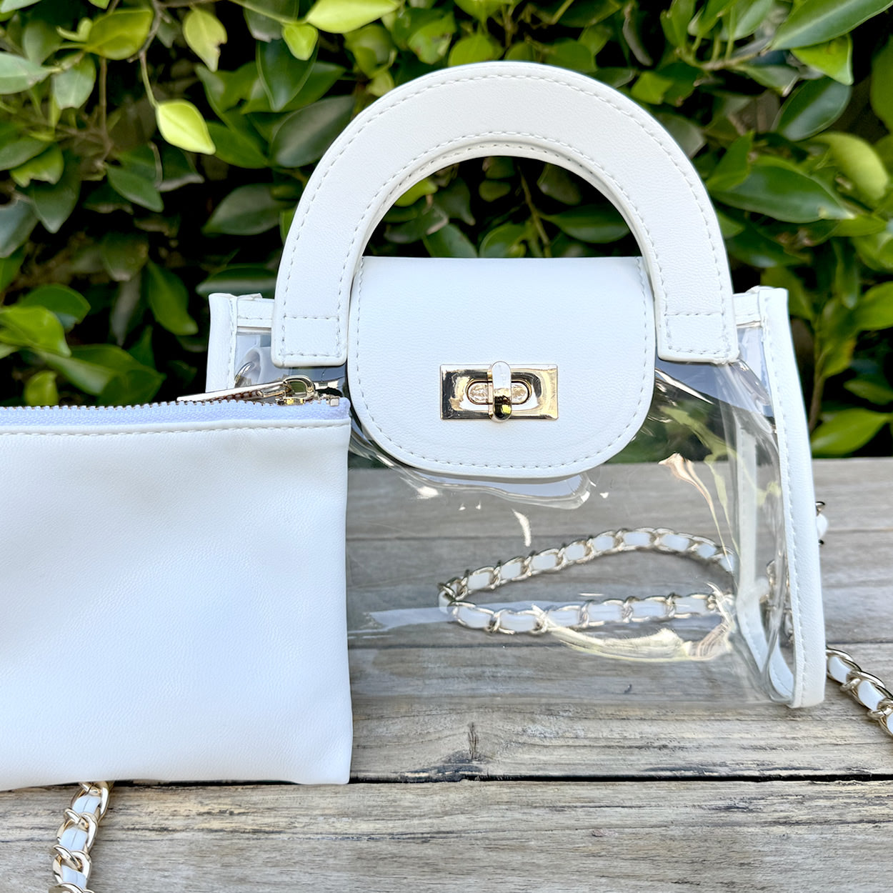 Clear, stadium-approved fashion purse with white faux-leather trim and a gold chain