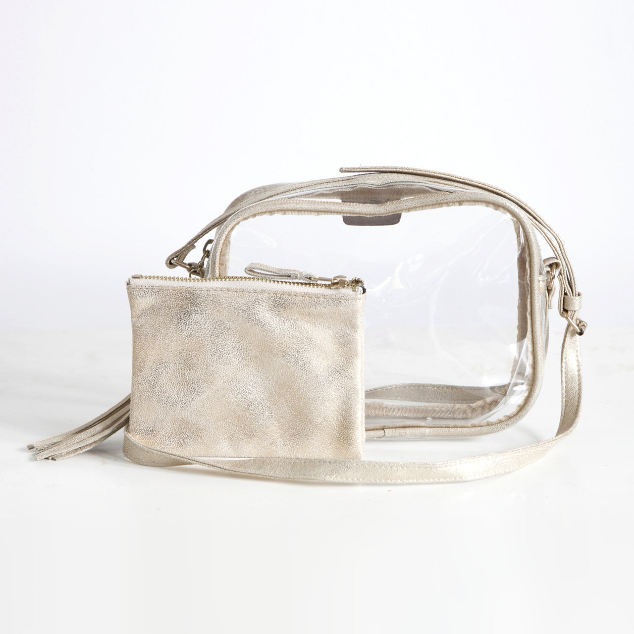 Clear, stadium handbag with gold trim, tassel, strap, and matching accessory pouch